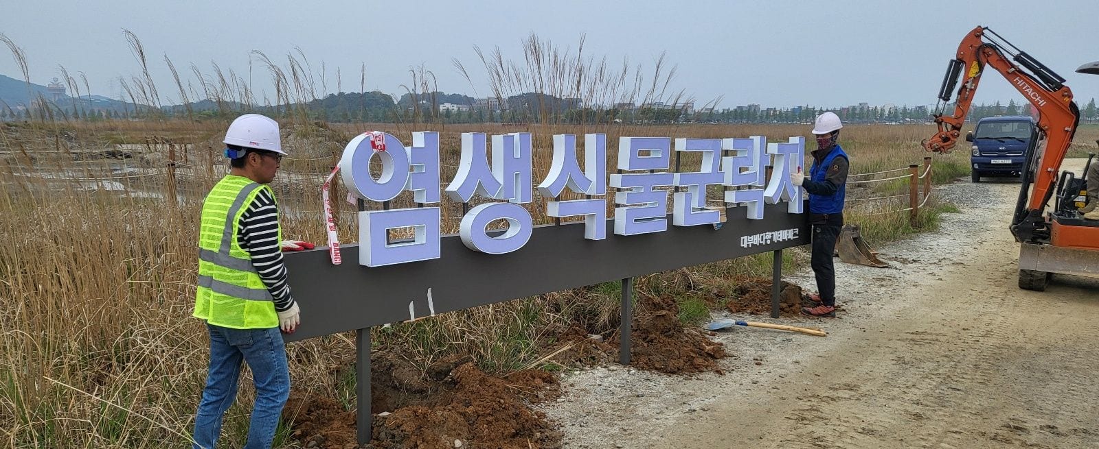 땅에 세우는 지주형 입체문자, 벽면 간판과 비교하면 기초부터 다릅니다 – 블록 위치를 확인하는 모습과 사인 끝을 잡아주는 모습
