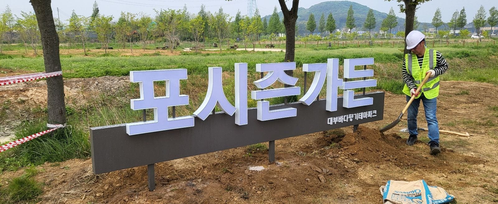 땅에 세우는 지주형 입체문자, 벽면 간판과 비교하면 기초부터 다릅니다 – 삽으로 흙을 되메우는 모습